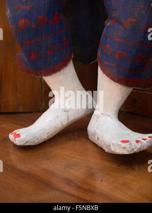 Pieds en bois thaïlandais avec des ongles peints en rouge montrant détouré peint sculpture presse à pantalons Banque D'Images