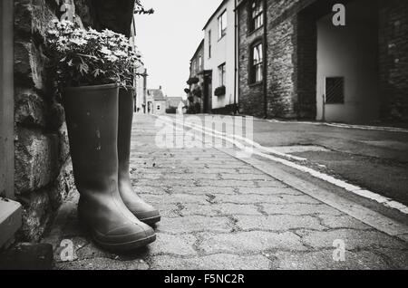 Ancienne paire de bottes wellington transformé en un pot de fleurs à l'extérieur d'un chalet à Malmesbury en Angleterre Banque D'Images