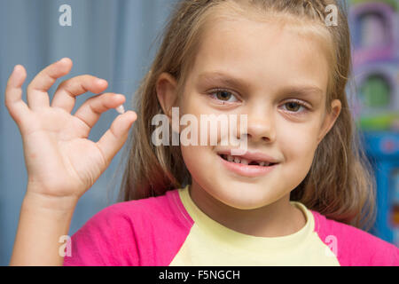 Cinq ans girl holding a chuté de dent supérieure avant Banque D'Images