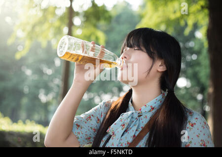 Asian girl drinking beverage Banque D'Images