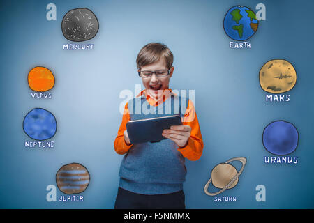 Teen Garçon à lunettes sourit et s'exécute sur une plaque grise de planètes Banque D'Images