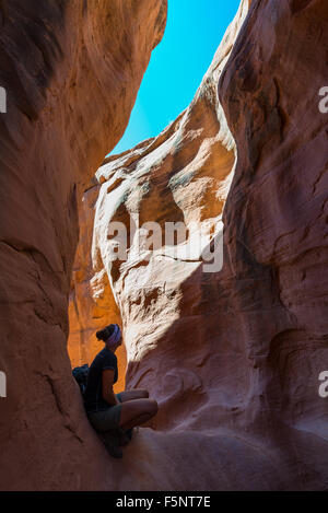 Une femme admire la lumière chaude dans le Ravin de Peekaboo Escalante Canyons de Grand Staircase Escalante National Monument (Utah). Banque D'Images