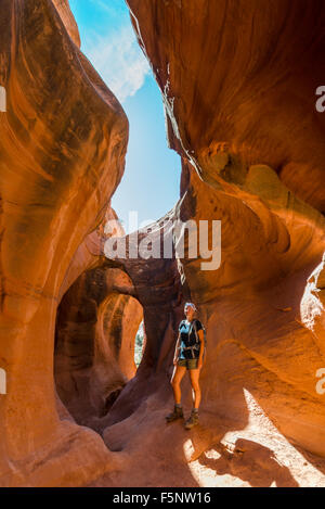 Une femme admire la lumière chaude dans le Ravin de Peekaboo Escalante Canyons de Grand Staircase Escalante National Monument (Utah). Banque D'Images