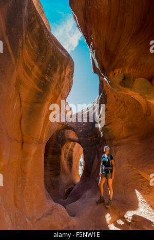 Une femme admire la lumière chaude dans le Ravin de Peekaboo Escalante Canyons de Grand Staircase Escalante National Monument (Utah). Banque D'Images