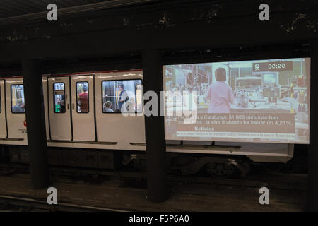 Télévision grand écran de télévision, en fournissant des nouvelles, annonces entre la voie ferrée à la station de métro, Barcelone,Espagne,Catalogne Banque D'Images