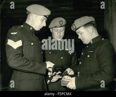 1954 - SOUS-OFFICIERS Dans Palace : Investiture de trois sous-officiers admirer leurs médailles à Buckingham Palace, Londres, aujourd'hui 17 novembre, après avoir reçu les insignes de leur prix dans une cérémonie organisée par la Reine Mère. (De gauche à droite) Le Caporal Reginald Copeman de Colchester, M.M. Pour les services en Malaisie ; Lance Caporal Anthony Cunningham de LIverpool, M.M. Pour les services en Oman, et le Sergent John Hawkins de Dumfries, en Écosse, RDR. Pour les services en Oman. © Keystone Photos USA/ZUMAPRESS.com/Alamy Live News Banque D'Images