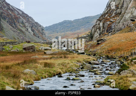 Snowdonia mountain pass avec jet dans une vallée escarpée. Vieux pont de pierre pittoresque traverse la rivière center shot avec les montagnes au loin. Banque D'Images