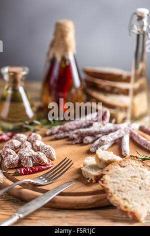 Ensemble de salami saucisses servis avec Red Hot Chili Peppers sur planche à découper en bois Banque D'Images