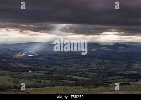 Rayons crépusculaires briser les nuages jusqu'à travers champs d'éclairage Shropshire, à partir de la Clee Hill en regardant vers le pays de Galles Banque D'Images