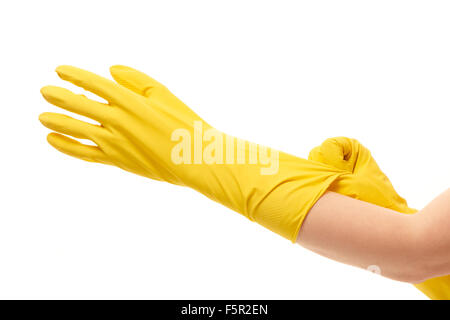 Les mains de mettre des gants en caoutchouc de protection jaune sur fond blanc contre Banque D'Images
