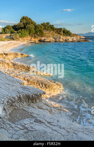 Les rochers sur la plage de Bataria, Kassiopi, Corfou sont éclairés avec la lumière du lever du soleil orange Stong. Banque D'Images