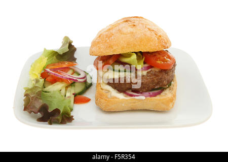 Dans un Cheesburger rouleau au levain avec de la salade et garnir sur une plaque isolés contre white Banque D'Images