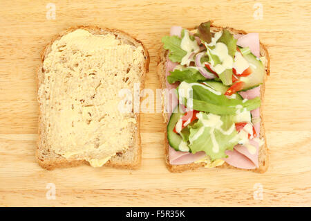 Deux moitiés d'un sandwich à la salade de jambon sur une planche en bois Banque D'Images