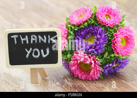 Merci écrit sur petite ardoise avec aster fleurs bouquet coloré Banque D'Images