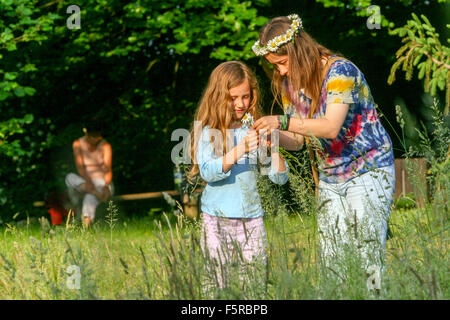 Deux filles fabriquant une couronne de tête dans Meadow Banque D'Images