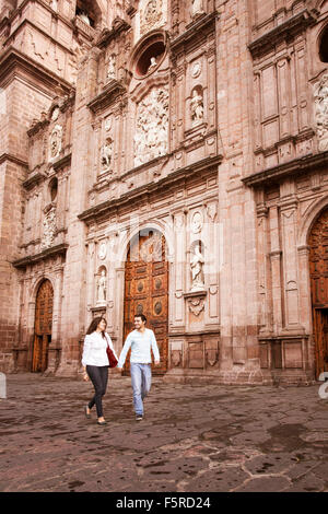 Jeune couple en train de marcher en face de la cathédrale de Morelia, Michoacan, Mexique. Banque D'Images
