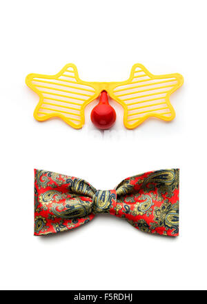 Partie lunettes et noeud papillon clown faisant face sur fond blanc Banque D'Images
