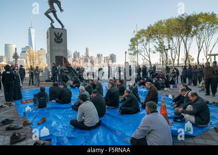 Jersey City, États-Unis. 05Th Nov, 2015. Après la prière, les hommes musulmans s'asseoir sur des bâches étalées près du lieu d'échange de la gare de chemin et d'écouter comme un imam parle. Les musulmans chiites se sont réunis à New York pour commémorer le martyre de Hussein ibn Ali, le petit-fils du prophète Mahomet, en participant à une procession de Muharram Exchange Place de l'Hôtel de Ville sur la rue Montgomery. Credit : Albin Lohr-Jones/Pacific Press/Alamy Live News Banque D'Images