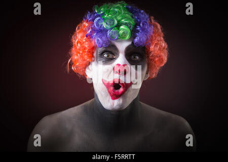 Evil Clown effrayant Portrait sur fond sombre. homme expressif Banque D'Images
