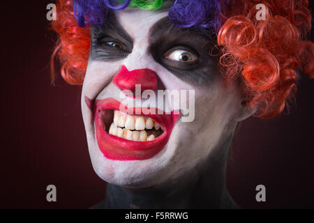 Evil Clown effrayant Portrait sur fond sombre. homme expressif Banque D'Images