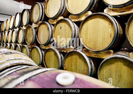 Détail tourné avec plusieurs tonneaux de vin en bois dans une cave Banque D'Images