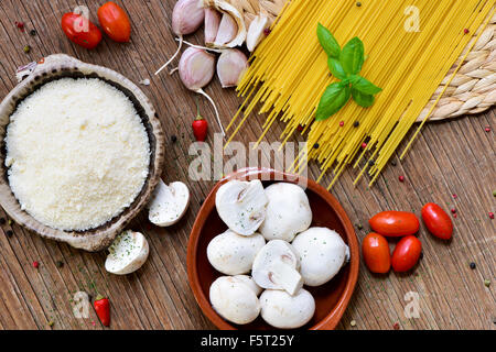 Capture d'un grand angle d'une table en bois rustique avec les ingrédients pour préparer une recette de pâtes, tels que le fromage râpé, ails, Mush Banque D'Images