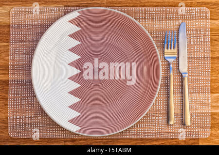 Assiette à dîner avec le drapeau du Qatar sur elle pour votre nourriture et boisson des concepts. Banque D'Images