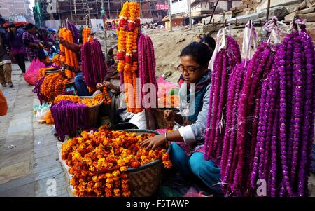 (151109) -- KATMANDOU, 9 novembre 2015 (Xinhua) -- vendeur local préparer des guirlandes de fleurs de souci et makhamali pour festival Tihar en face des ruines du temple Kastamandap Hanuman Dhoka à Durbar Square de Katmandou, Népal, Novembre 9, 2015. 'Le', Tihar festival hindou des lumières, est célébré pendant cinq jours. Chaque jour est consacré à différentes personnalités religieuses y compris la vache, Crow, et le chien, qui signifie des relations entre les êtres humains, Dieu, et les animaux. (Xinhua/Sunil Sharma) Banque D'Images