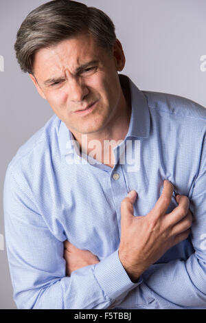Studio Shot of mature Man souffrance Crise cardiaque Banque D'Images