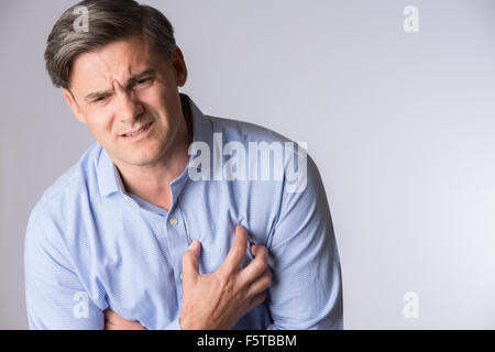 Studio Shot of mature Man souffrance Crise cardiaque Banque D'Images