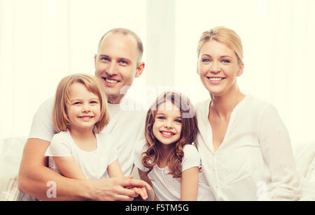 Smiling parents et deux petites filles à la maison Banque D'Images