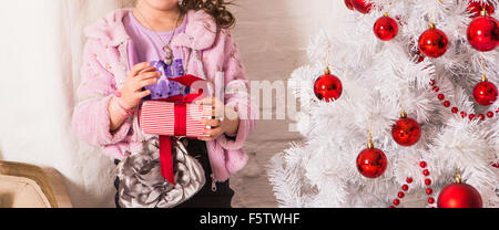 Petit enfant heureux avec des cadeaux et l'arbre de Noël Banque D'Images