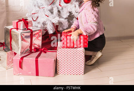 Petit enfant heureux avec des cadeaux et l'arbre de Noël Banque D'Images