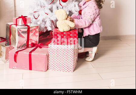 Petit enfant heureux avec des cadeaux et l'arbre de Noël Banque D'Images