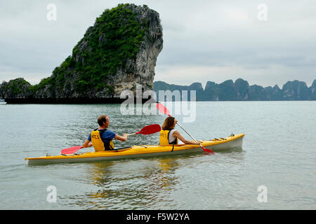 Couple kayak et de calcaire (karst) mound, Ha Long Bay, Secteur de Bai Tu Long, près de Ha Long, Vietnam Banque D'Images