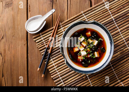 Soupe miso au tofu, algues et de sésame dans un bol sur fond de bois Banque D'Images