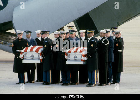 Camp Springs, Maryland. USA 12 décembre 1984 Le corps de deux Américains tués par les pirates de la semaine dernière à l'Iran ont été apporté à la maison à Andrews Air Force Base. Les cercueils contenant les restes de Charles F. Hegna et William L. Stanford, les deux commissaires aux comptes de l'Agence pour le développement international sont menées à partir de la C141de cargo par deux groupes de gardes d'honneur en uniforme habillé de bleu manteaux et gants blancs. Credit : Mark Reinstein Banque D'Images