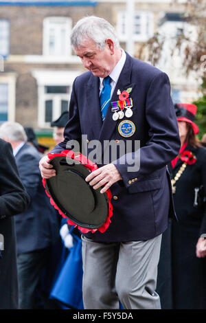 L'Angleterre, Ramsgate. Le Jour du Souvenir, en novembre. Les anciens combattants, le port des médailles portant coquelicot couronne au monument commémoratif de guerre du Canada au cours d'une cérémonie à la pluie. Banque D'Images