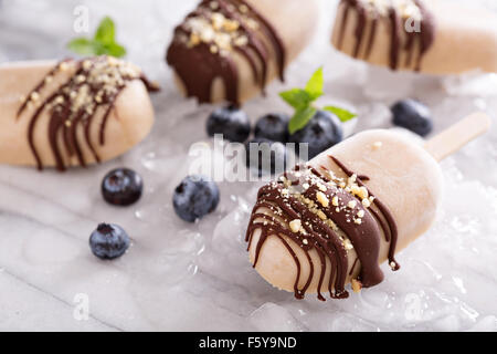 Sucettes glacées au beurre d'arachide et banane avec du chocolat fondu Banque D'Images