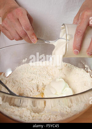 Ajouter la crème sure. La fabrication du chocolat Layer Cake avec de la crème de Fromage et chocolat Topping. Série. Banque D'Images