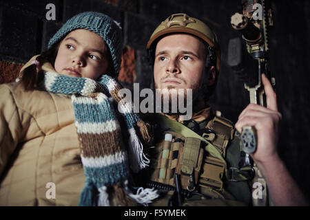 L'homme militaire en tenue de camouflage et little girl holding gun Banque D'Images