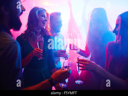 Cheerful friends with champagne passer du temps dans une boîte de nuit Banque D'Images