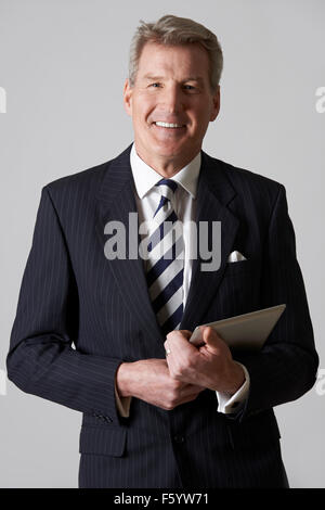 Studio Portrait Of Businessman Holding Digital Tablet Banque D'Images
