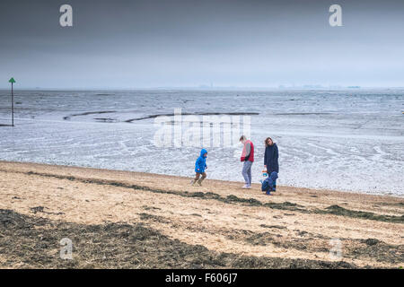 Une famille brave le froid sur le quai de Bell Plage de Leigh on Sea, Essex. Banque D'Images