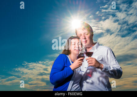 Avec quelques verres de vin embrasse sous les rayons du soleil couchant Banque D'Images