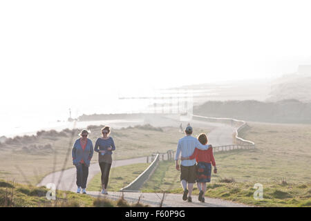 Des couples sur le chemin qui va de Mudeford village au cabanes de plage à Mudeford, Christchurch Harbour, près de Poole, Dorset, Angleterre, Banque D'Images