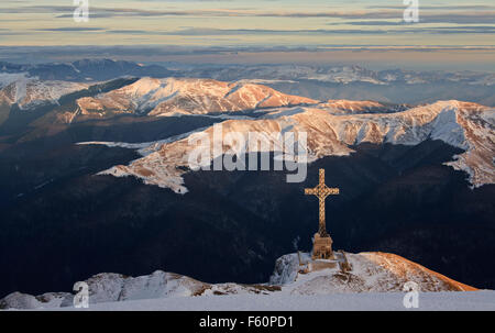 Grande croix sur la vallée en hiver sur le coucher du soleil Banque D'Images