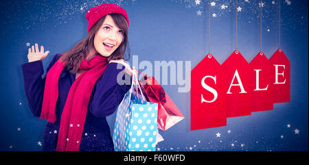 Libre de brunette in winter clothes holding shopping bags Banque D'Images