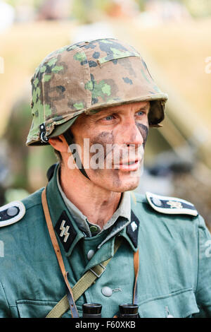 WW2 re-enactment. Waffen SS, portrait. Close up, la tête et les épaules. SS insigne sur revers. La peinture de camouflage noir sur le visage. Banque D'Images