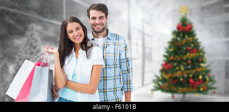 Image composite de l'heureux couple with shopping bags Banque D'Images